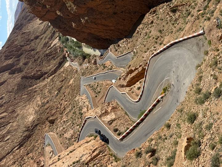 A dramatic series of hairpin bends snakes through steep rocky canyon walls in Morocco