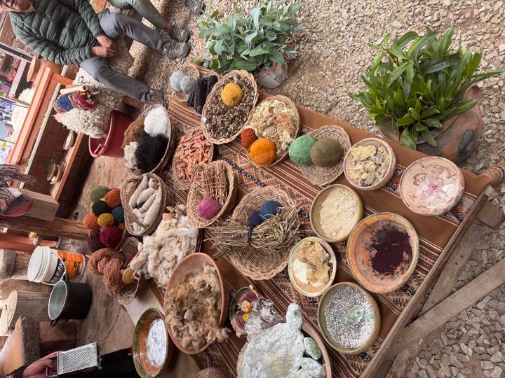 Display table of natural dyes, yarns and Andean weaving materials in an artisan workshop.