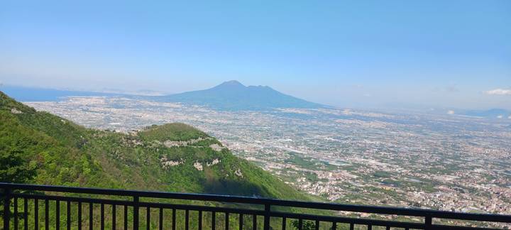 Panoramic viewpoint overlooking sprawling plains with Mount Vesuvius dominating the horizon.