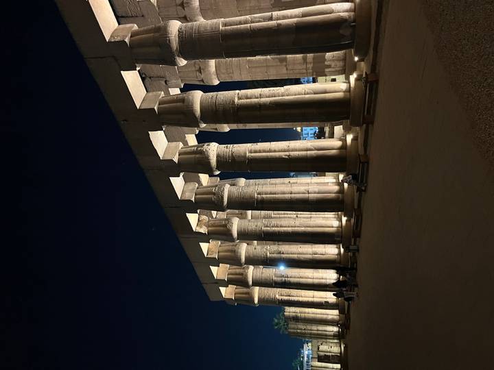 Impressive colonnade of Luxor Temple dramatically lit against the night sky.