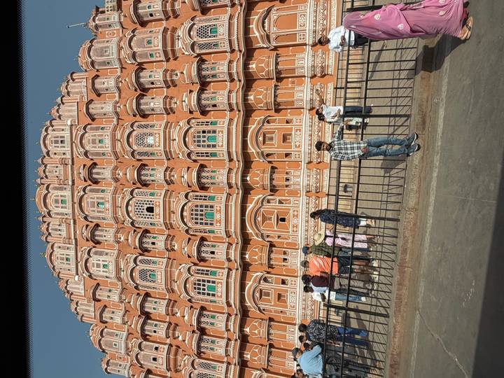 Front view of Jaipur’s Hawa Mahal with visitors standing by the railing