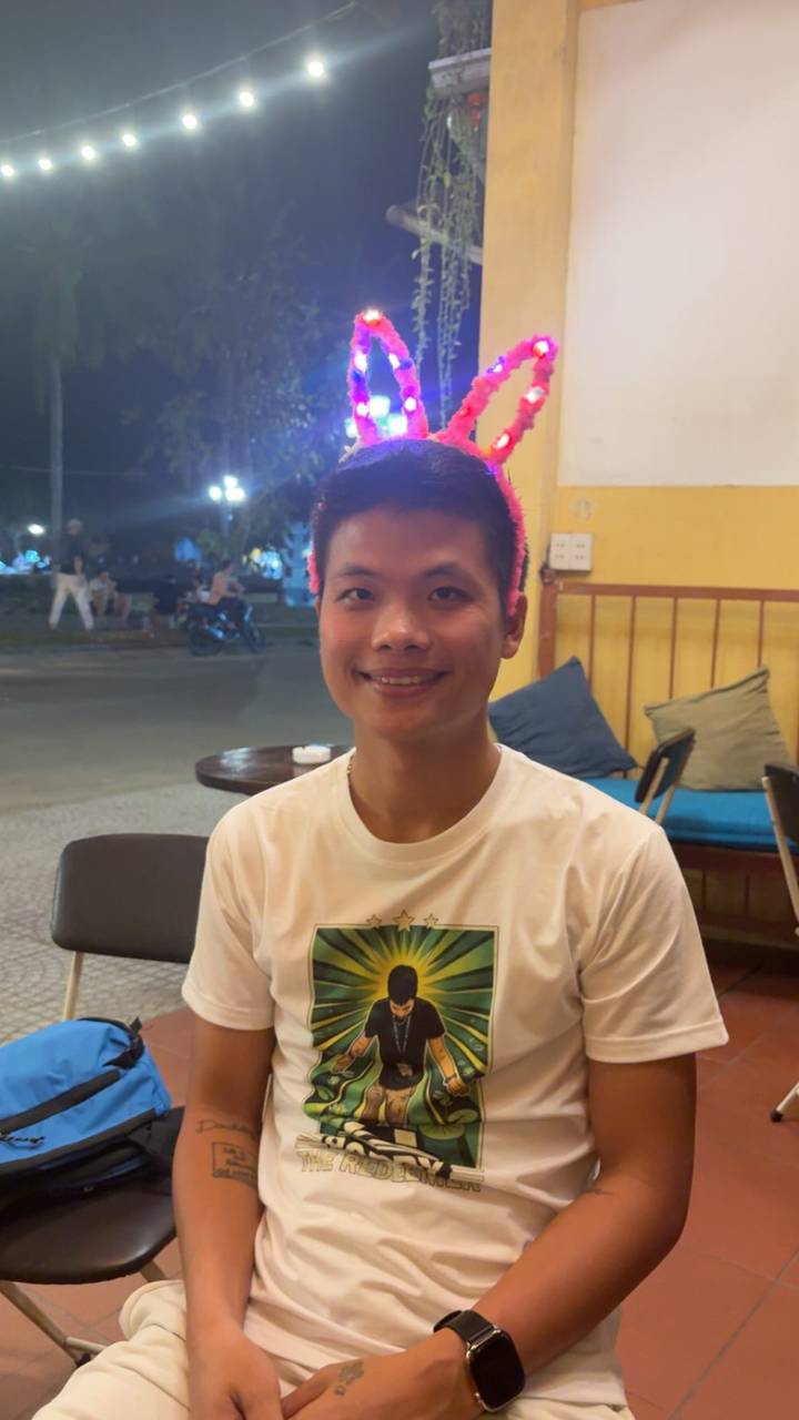 Portrait of a smiling young man in a casual café at night.