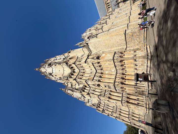 Dramatic upward view of York Minster’s soaring Gothic tower under a deep blue sky.