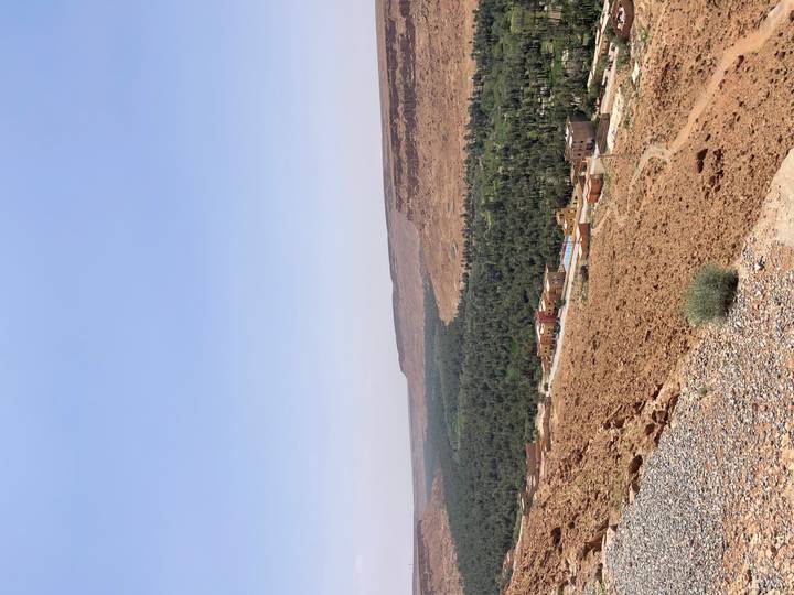 High desert plateau view overlooking a green oasis valley and small village