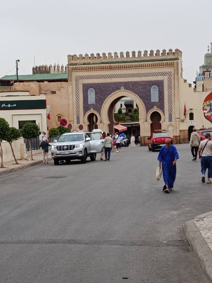 Traffic and pedestrians pass through the ornate blue-tiled Bab Bou Jeloud gate in Fes.