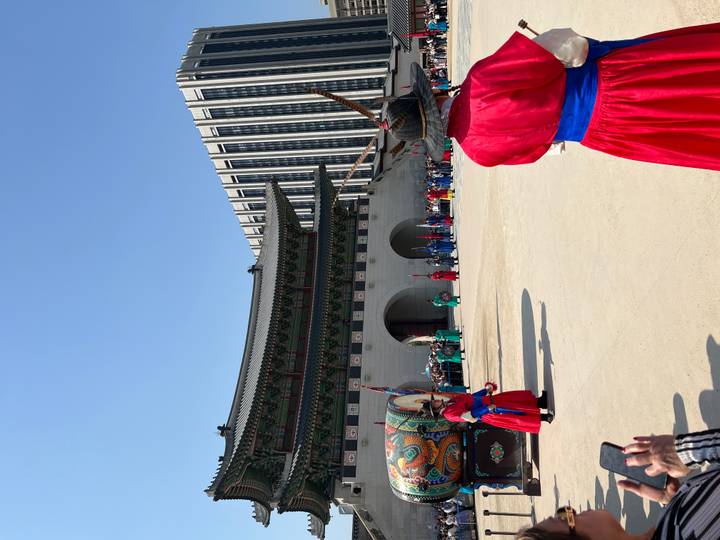 Changing of the guard ceremony in front of the main gate of Gyeongbokgung Palace with colorful uniforms.