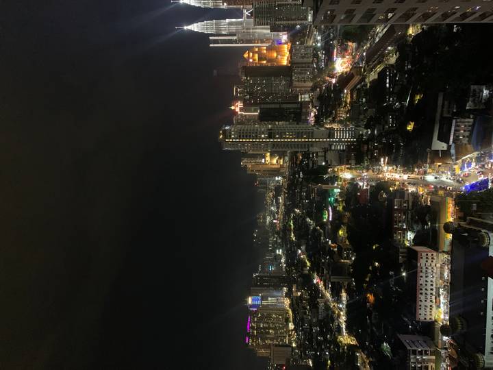 A sweeping night view of Kuala Lumpur’s illuminated skyline with traffic trails below.