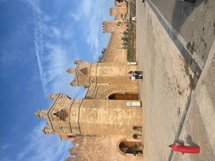 Impressive fortified gate with crenellated towers in Rabat under a bright blue sky.