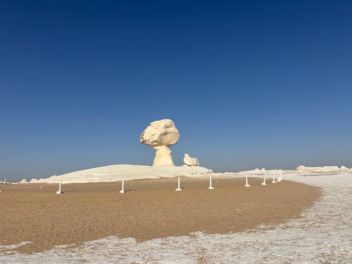 Iconic white limestone mushroom rock formation standing against deep blue sky.