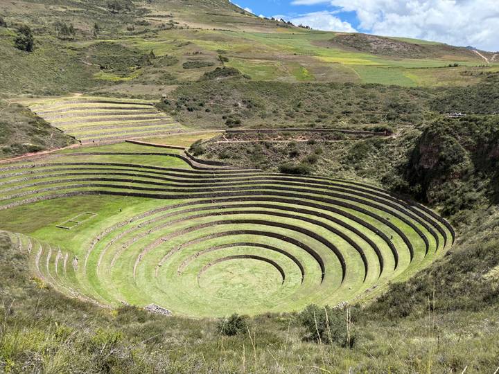 Terraced concentric agricultural circles of Moray archaeological site surrounded by green fields.