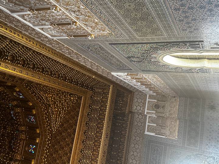 Intricately carved and gilded ceiling and archway in a Moroccan palace or medersa.