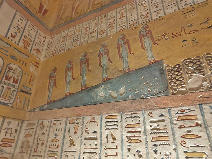 Colorful, well-preserved wall reliefs depicting ancient Egyptian deities inside a tomb in the Valley of the Kings.