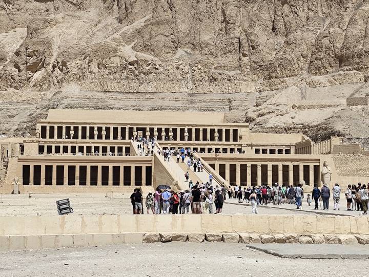 Crowds ascending the terraces of Hatshepsut’s mortuary temple set against rugged desert cliffs.
