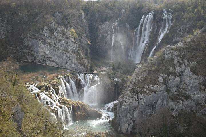 Multiple cascading waterfalls and turquoise lakes within the limestone cliffs of Plitvice Lakes National Park.