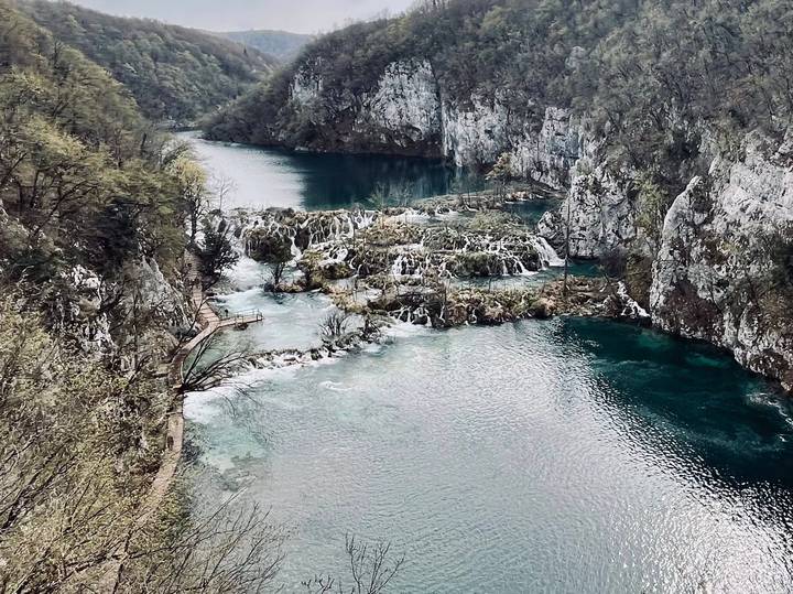 Deep canyon of emerald water and white cascades weaving through limestone cliffs at Plitvice.