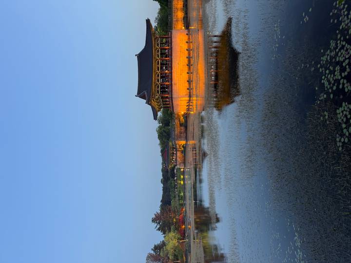 Historic pavilion glowing at dusk, reflecting in the tranquil pond at Wolji in Gyeongju.