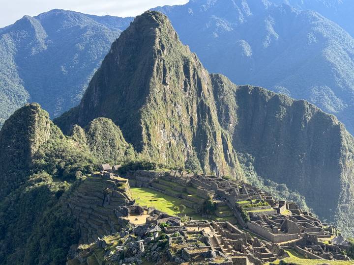 Iconic aerial view of Machu Picchu ruins framed by steep green peaks.