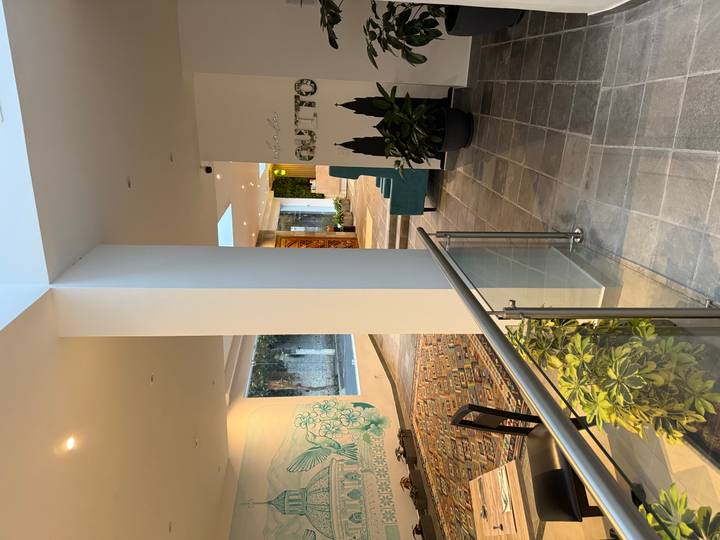 Lobby area of a modern hotel with Quito-themed wall art, plants and stylish seating.