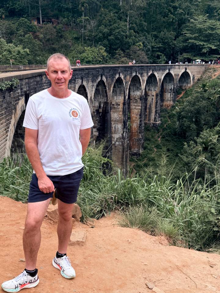 Traveller stands before the iconic Nine Arches railway bridge spanning a deep jungle gorge.