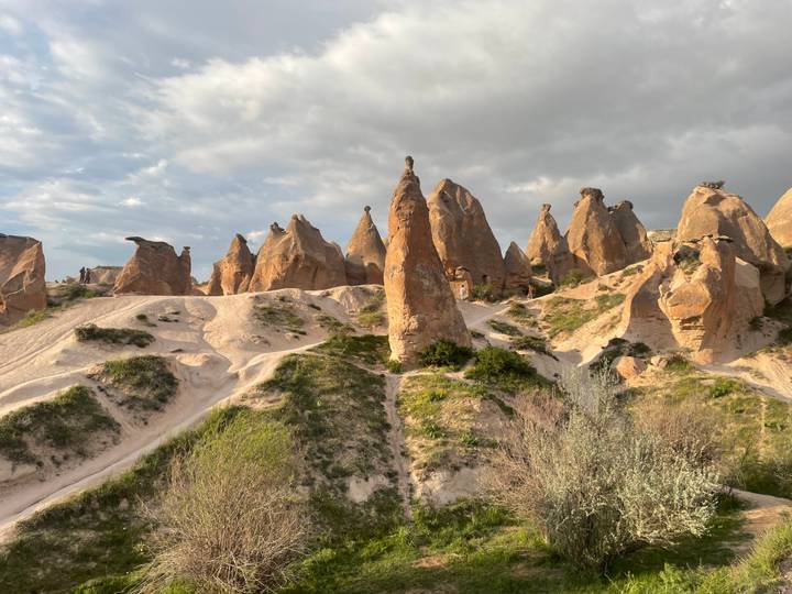 Unique rock spires and soft sand formations in Cappadocia under dramatic clouds
