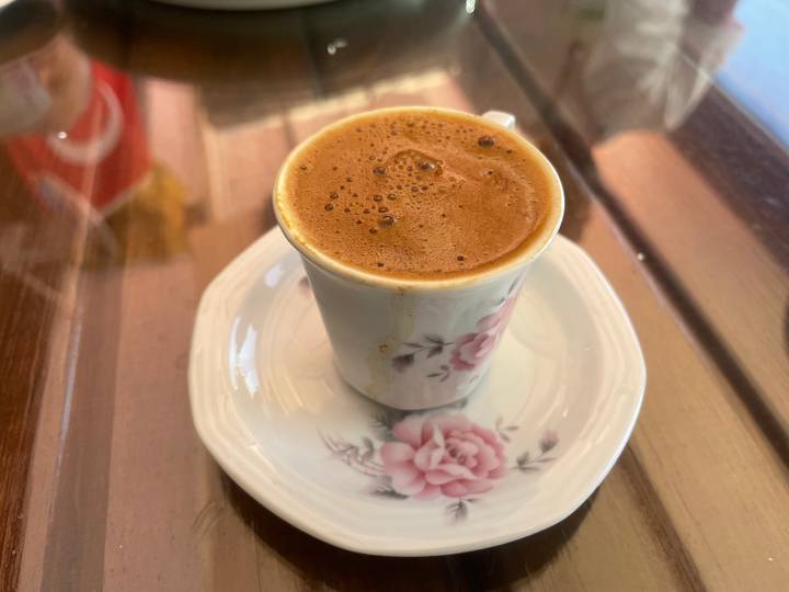 Traditional Turkish coffee served in a small floral porcelain cup on saucer