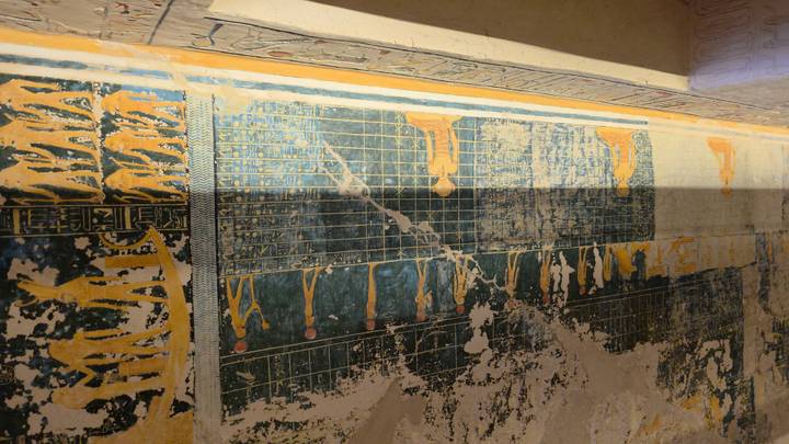 Faded yet intricate star charts and figures decorate the painted ceiling of an ancient tomb.