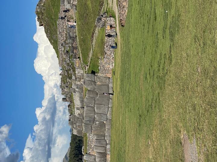 Massive interlocking stone terraces of Sacsayhuaman with visitors exploring the site