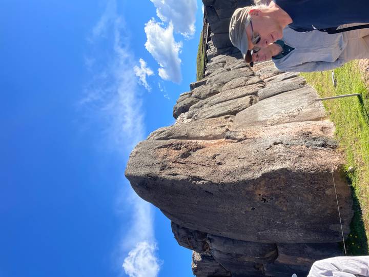 Giant volcanic stone block walls of Sacsayhuaman with a tourist in the foreground