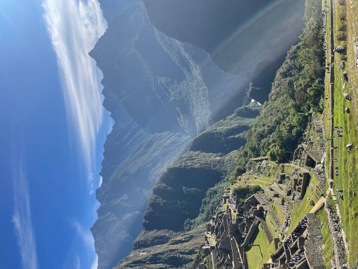 Sweeping panorama of Machu Picchu with sun rays cutting through the Andean peaks