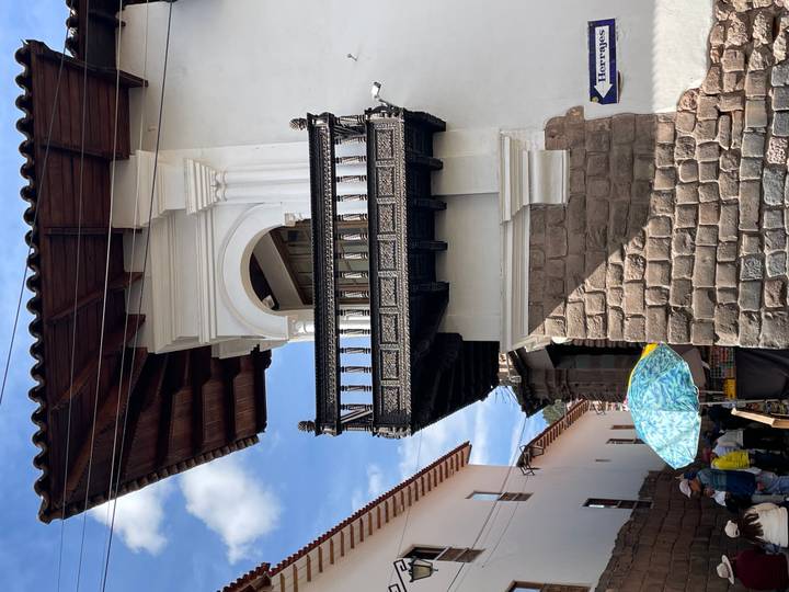 Alternate angle of historic Cusco wooden balcony with street activity below
