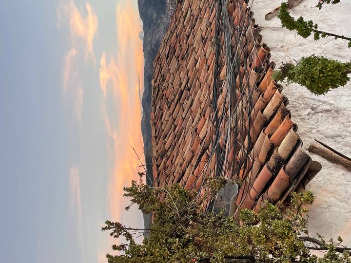 Warm sunset sky over terracotta roof tiles of a traditional Andean house