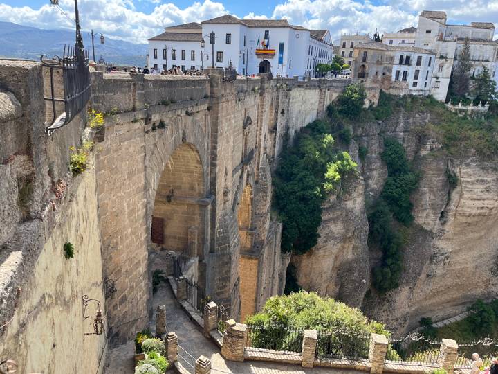 Dramatic view of Puente Nuevo bridging a deep gorge with whitewashed buildings perched atop cliffs in Ronda.