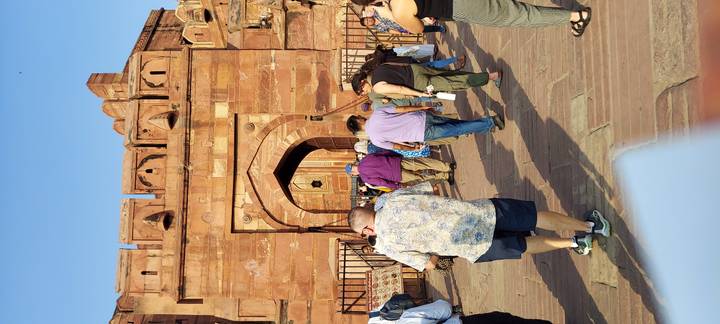 Tourists queue through massive red sandstone gateway of Agra Fort