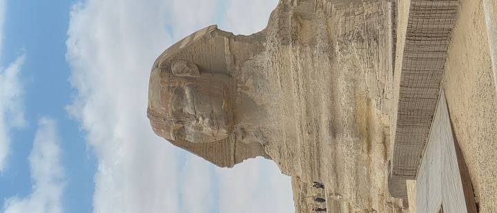 The Great Sphinx of Giza carved from limestone against a partly cloudy sky