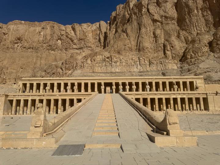 Symmetrical frontal view of the grand terrace and ramps of the Temple of Hatshepsut carved into sheer cliffs
