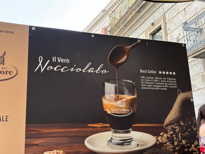 Advertising board showing a glass of thick creamy espresso drink labelled 'Il Vero Nocciolato'
