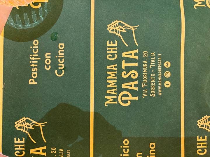 Green menu card highlighting the restaurant 'Mamma Che Pasta' with address details in Sorrento