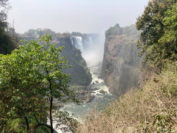Spectacular view into the gorge of Victoria Falls with powerful water flowing between steep cliffs