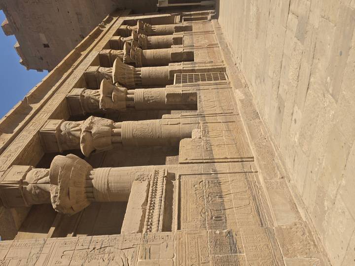 Sandstone columns with Hathor-headed capitals and carved reliefs at Philae Temple.