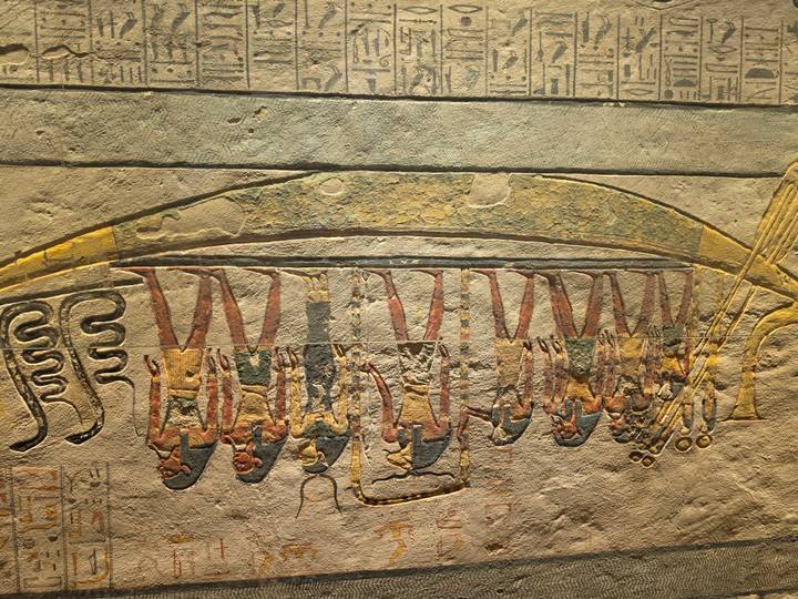 Colorful wall painting of ancient Egyptian figures aboard a boat, preserved with vivid detail.