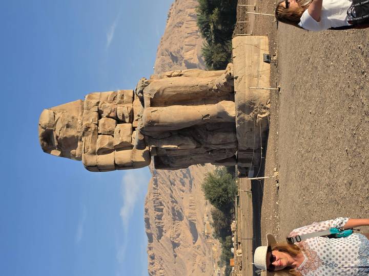 Second weather-worn Colossus statue standing on a barren plain with desert mountains behind.