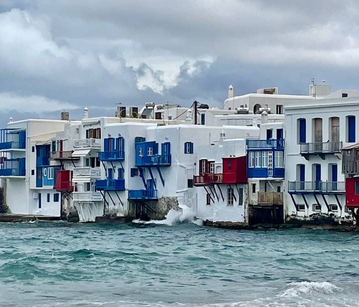 Row of whitewashed seaside houses with colorful wooden balconies in Little Venice, Mykonos