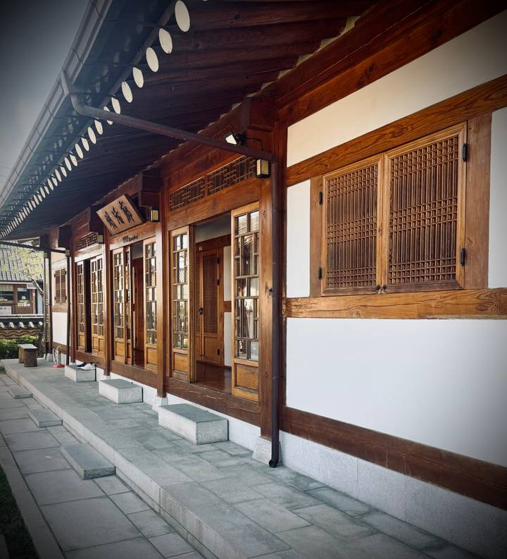 Wooden hanok corridor with lattice windows and soft sidelight in traditional Korean village