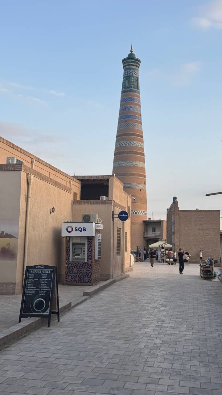 Historic streets of Khiva with stubby Kalta Minor minaret and evening crowds