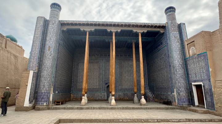 Wood-columned hypostyle hall of the Juma Mosque in Khiva with blue-tiled walls