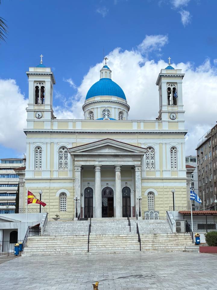 A grand three-storey church with a bright blue dome, twin bell towers and classical columns dominates the square.