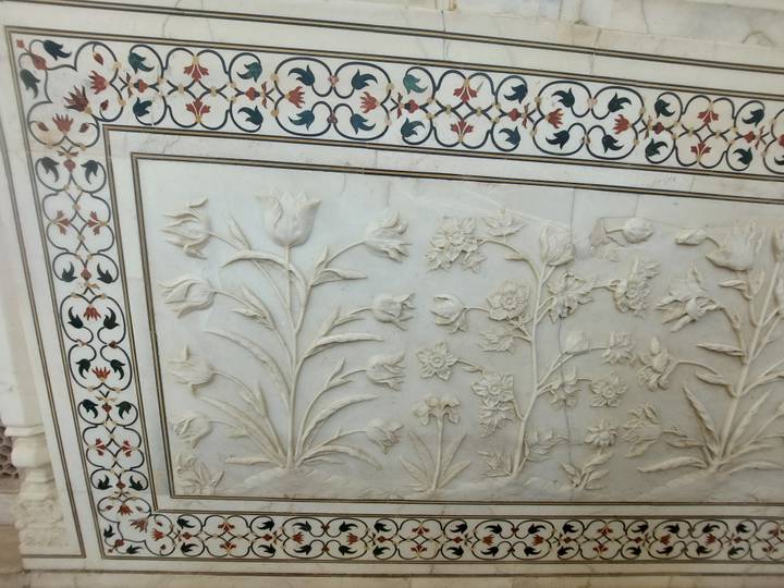 Close-up of white marble floral inlay and carving with intricate border patterns