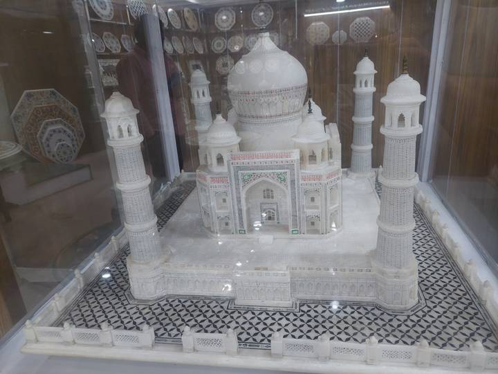 Detailed miniature model of the Taj Mahal displayed in a glass case