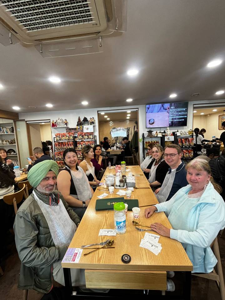 Tour group enjoys a traditional Korean meal around a wooden restaurant table