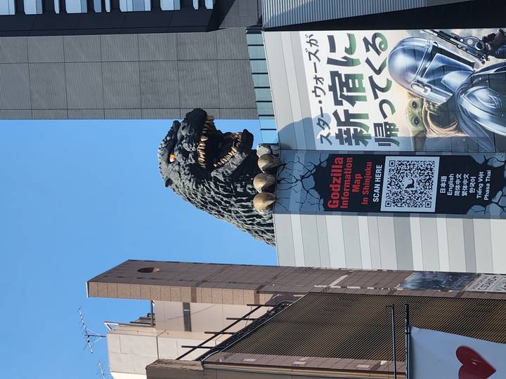 Iconic Godzilla head sculpture looming over a Shinjuku building façade